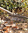5 Ft Metal Lawn Rake With Level Head And 14 Tough Tines Stainless Steel Handle For Deep Loosening Of Soil in use on leaves