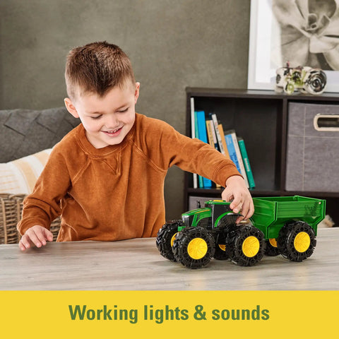 Child playing with Rad Monster Treads Tractor Toy With Wagon Lights And Sounds Monster Truck Tire Action John Deere Farm Playset