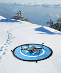 Waterproof Portable Foldable Helipad Landing Mat For Drones 22 Inch 55cm on snowy terrain with DJI drone, outdoor use.