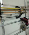 Garage Door Storage Rack for Fishing Gear 21 Inch Black ABS Rod Holder installed on garage wall with tools.