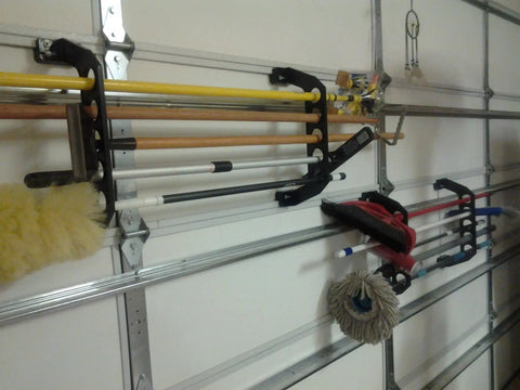 Garage Door Storage Rack for Fishing Gear 21 Inch Black ABS Rod Holder installed on garage wall with tools.