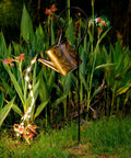 Sun Powered Watering Can Lights For Garden With Cascading LED Pouring Water Effect on metal hook in garden scene