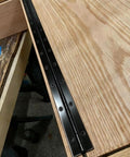 Heavy Duty Top Shelf Black Piano Hinge 48 Inches X 3 Inches Wide Stainless Steel Continuous Gate Door Hardware Tough Finish Cut To Size Quick Install installed on wooden surface showing screws.