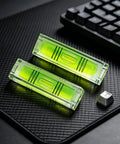 2 Pack Magnetic Mini Bubble Level Tool 2 Inch, Small Pocket, featuring strong magnet and measurement grid, placed on a textured surface.