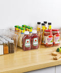 Straight Fire Kitchen Organization To Keep The Mess Tight With This Six Pack Of Large Clear Pantry Bins Boasting Heavy Duty Handles For Fridge Cabinet Freezer Sorting, filled with sauces and spices on a wooden countertop.