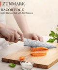 Eight Inch Damascus Steel Chef Knife With A Smooth Olive Wood Handle And Razor Sharp 10Cr15CoMoV Core slicing salmon on wood board.