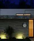 LED Illuminated Outdoor Clock With Temperature And Humidity, 24 Inch Black, installed on a patio wall at night