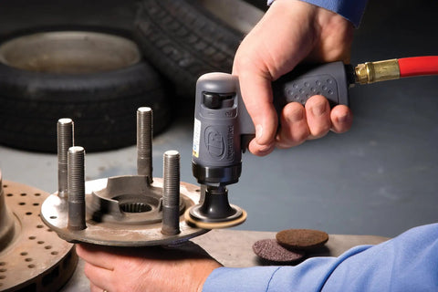 Person using Mini Surface Prep Sander Kit With 14-Piece 2-Inch And 3-Inch Sanding Discs on automotive part in garage.