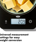 Everyday Glass Kitchen Scale For Meal Prep, Digital Food Scale With 11lb/5kg Capacity displaying 20.9 oz on screen with butter cubes
