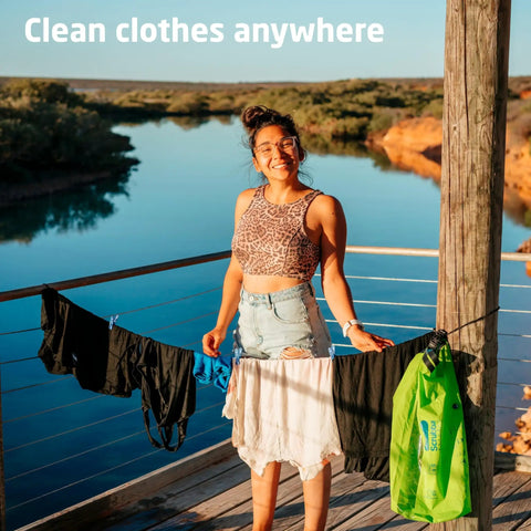 Heavy Duty Travel Laundry Sack Featuring Slick Inner Washboard Grooves Keeps Your Everyday Threads Fresh Camping Trips RV Adventures And Hotel Stays Lightweight Quick Rinse Gear Bags Cut Laundromat Headaches Fast, displayed by a smiling person with clean clothing hanging outdoors.