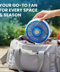 Blue Steel Portable Desk Fan With 360 Degree Oscillation placed in a bag outdoors, ideal for home office travel and outdoor camping.