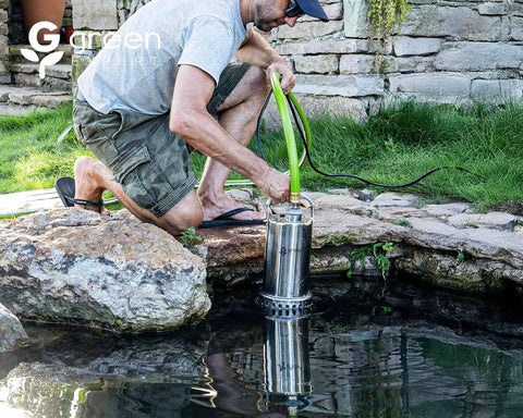 Front view of Green Expert stainless steel submersible sump pump in a garden pond with a bright green hose attached.