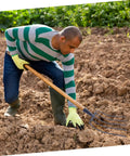Man using Durable Heavy Duty Multi Functional Manure Fork Handheld Tool For Outdoor Farming And Lawn Maintenance on tilled soil