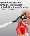 Person using red fire extinguisher with painted steel handles and metal valve, part of Two In One Smoke And Carbon Monoxide Detector With AA Battery Power And LED Warning Indicators Plus Home Fire Extinguisher With Mounting Bracket Included For Easy Safety Upgrades.