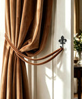 Top Shelf 2 Pack Black Wall Hooks for Kitchen and Bathroom, Vintage Farmhouse Decor, Heavy Duty and Sturdy Coat and Towel Hooks with Classic Matte Finish that brings Badass Charm to any Room, featuring a brown curtain tied with a black wall hook.