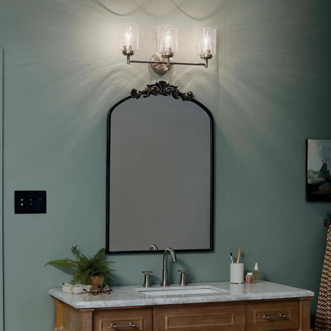 Three Light Vanity Light In Brushed Nickel With Clear Seeded Glass, Modern Transitional Bath Fixture above a bathroom mirror.