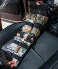 Front view of Rhino Rescue car IFAK trauma kit in MOLLE pouch on vehicle seat, tourniquet and gauze visible