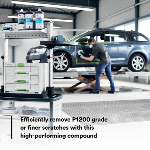 Pro Grade High Performance Rubbing Compound For Clearcoats That Wipe Out Fine Scratches Without Sticking Or Leaving Residue, Great For Newer Paint Finishes, Smooth Handling, One Gallon. One-gallon rubbing compound on shop cart beside car polishing work