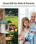Solar Powered Bird Feeder With Camera For Outdoor Use AI Recognition And Real Time Alerts Wireless Bird House Viewable On Your Phone Treat Birds With Fruit Or Suet And Enjoy Bird Watching From Anywhere Perfect Gift For Mom Or Dad installed on a tree with family watching video on phone.