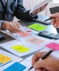 Bright Lined Sticky Notes 4x6 Inches Pack Of 15 With 7 Bold Colors used during a business meeting on a desk with documents.