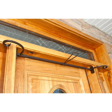 No Sweat Setup Front Door Garland Hanger With Thick Rubber Padded Ends For Year Round Decor Fits Wide Doorjambs No Drill Needed Holds Twenty Pounds Like A Champ Straight Up Heavy Duty Steel mounted above a wooden door.