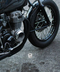 2 Piece Adjustable Cam Chain Tensioner For Cruiser Motorcycle Fine Thread Extender on ground near motorcycle engine.