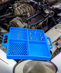 Silicone Fastener Tray For Bolts, Nuts, And Bits With Handy Handle placed on car engine bay showing storage compartments.