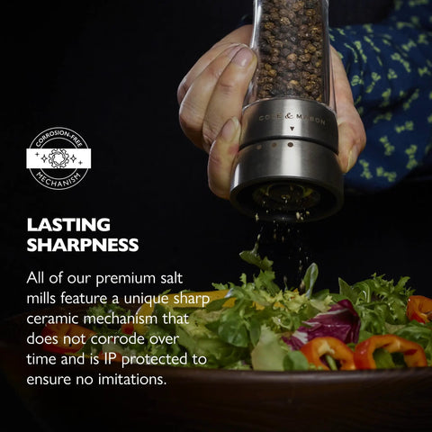 Pepper Grinder With Adjustable Six Level Grind, Stainless Steel Mill in use, grinding pepper onto a fresh green salad bowl.