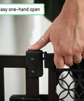 Hand operating No-Drill Expandable Baby And Dog Gate 28 To 42 Inch Wide, 30 Inch Tall, Espresso, showing easy one-hand open feature