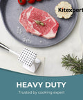 Meat Tenderizer Hammer With Comfortable Grip Handle Dual Sided Mallet next to raw steak on plate with garlic and rosemary