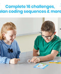 Students using Scratch Block Based Coding Kit for Ages 8 to 12 with cards and activity sheets on a table in classroom.