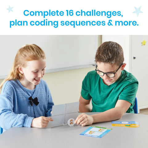 Students using Scratch Block Based Coding Kit for Ages 8 to 12 with cards and activity sheets on a table in classroom.