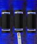 Three Up and Down Outdoor Smart Wall Light With RF Remote Color Changing RGB And CCT 2700K To 6500K White Temperature 9 Modes Exterior Wall Light compatible with Alexa and Google Assistant illuminating a wall with blue light.
