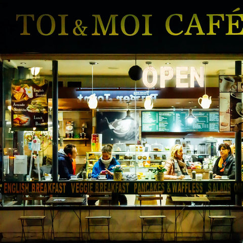 Nighttime view of café with 30x10 Inch LED Open Sign For Business With Boss Level Brightness, warm ambiance inside.
