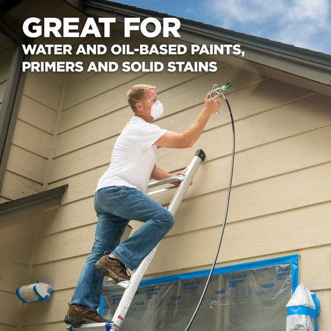 Man using High Efficiency Airless 515 Reversible Spray Tip For Solid Stain Paint And Primer on house siding, 10-12 inch spray pattern.