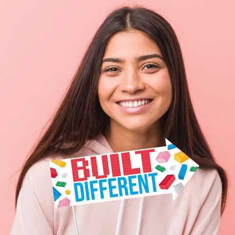 Awesome Funny Building Blocks Birthday Photo Booth Prop Kit Featuring Colorful Bricks Speech Bubbles And Arrow Signs For Super Dope Diy Party Setup Exactly Ten Pieces Chill Vibes with a smiling girl holding a 'Built Different' sign.