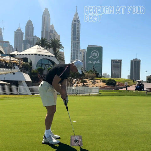 Golfer using Putting Arc Golf Training Aid For A Perfect Stroke Adjustable Arc Practice Mat on the course with city skyline background.