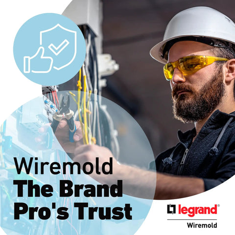Electrician with yellow safety glasses working on wiring with tools in a professional setup, Wiremold branding visible.