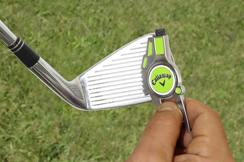 Person using Super Handy Four In One Golf Divot Repair Tool Built With Tough Zinc Alloy For Avid Golfers Looking For A Reliable Multi Function On Course Accessory That Makes A Great Gift on iron club.