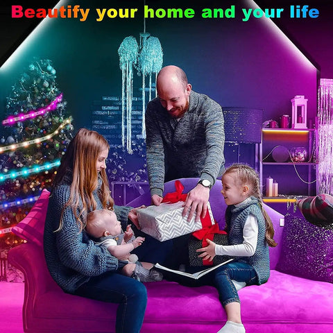 Family in living room with LED Strip Lights For Bedroom With Music Sync, App Control And Remote, Color Changing RGB Light Strips For Room Decor, Party Ambience, 30 Foot, Easy Install, Self Adhesive Tape, Flexible Setup, Great For Dorm Rooms, Gaming Setups And Movie Nights; father giving gift to daughter, colorful lighting on Christmas tree in background