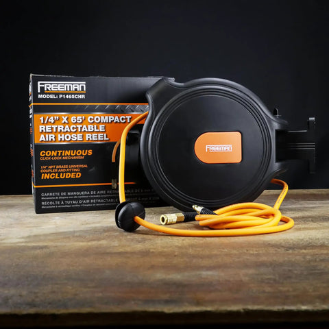 Compact Retractable Air Hose Reel with brass fittings, 1/4 inch by 65 feet, mounted on wooden surface.