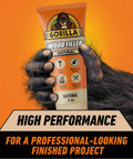 All Purpose Wood Filler Natural Color 6 Ounce Tube pack held by a gorilla hand with high performance label, for indoor and outdoor repairs.