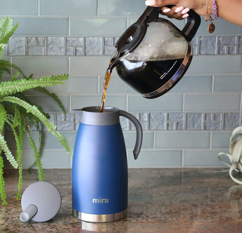 Pouring coffee into Stainless Steel Thermal Carafe Dispenser Vacuum Insulated Dual Wall Bottle For Hot Coffee Tea Or Cold Water 1.5 Liter 50oz Keeps Drinks Hot 12 Hours Cold 24 Sweat Free Admiral Blue on kitchen counter