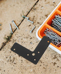 Beefed-Up Heavy Duty L Shaped Corner Brackets Set in Black Stainless Steel with screws and tools on a workbench background