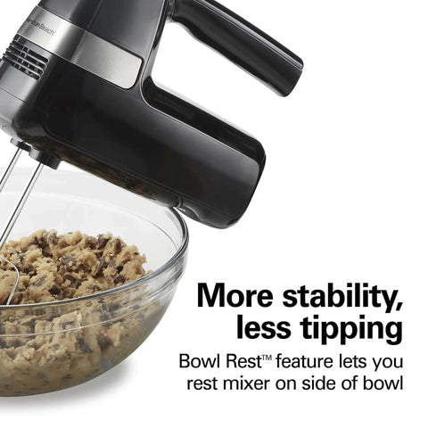 Slick Electric Hand Mixer Packing Six Speeds Plus A Dedicated Stir Button To Dodge Splatter While Whipping Up Thick Dough Or Fluffy Batter Plus Dual Beaters And Heavy Duty Hook Attachments resting on the side of a bowl with cookie dough.