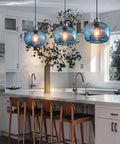 Hand Blown Marble Blue Glass Pendant Light For Kitchen Island Over Dining Table Dope Modern Farmhouse Globe Eight Point Seven Inch Ceiling Fixture In Brushed Nickel Finish With Easy Install And Balanced Hanging in a modern kitchen setting.