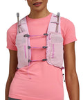 Close-up of a woman wearing the Pinnacle Pro 6L Women's Hydration Vest With Second Skin Fit In Light Pink Fuchsia, showing front pockets.