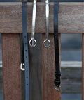 Premium English Leather Spur Straps for equestrian riding, 20 inch black with durable construction shown on a wooden backdrop