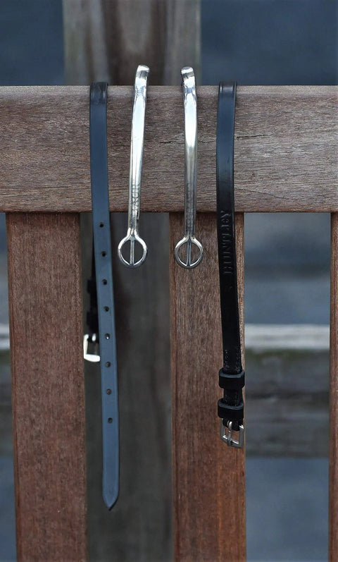 Premium English Leather Spur Straps for equestrian riding, 20 inch black with durable construction shown on a wooden backdrop
