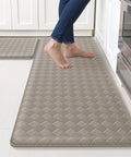Cushioned Anti Fatigue Kitchen Mats Set 2 Pack Non Slip Floor Rugs For Standing At Sink Or Stove Waterproof Kitchen Mats For Sink And Stove 17.3x30 And 17.3x47 Inches Brown depicted with a person standing on them in a kitchen setting.